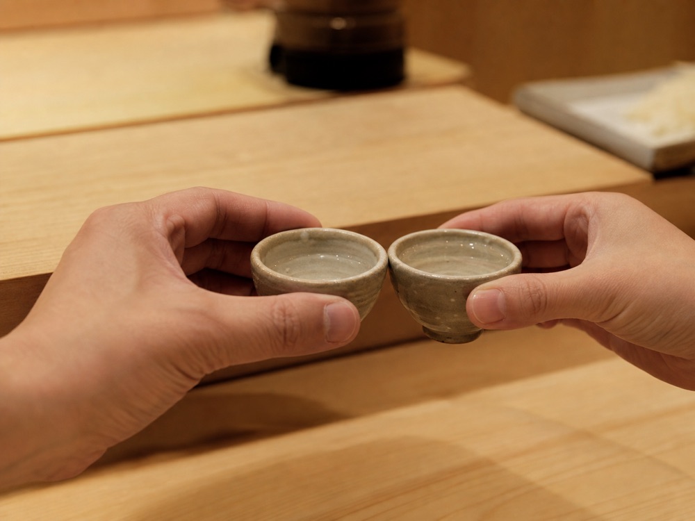 酒杯を交わす手元(イメージ)
